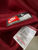 Maroon Nike Portugal home shirt sleeve with neck label and size tag, close-up