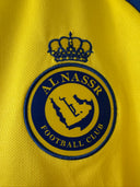 Yellow soccer jersey featuring large Al Nassr Football Club crest emblem