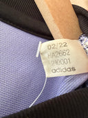 Adidas size tag on light purple football shirt collar, barcode label