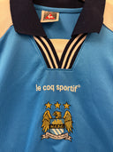 Light blue soccer jersey with black-and-gold V collar trim and club crest