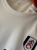 White football shirt neckline close-up with brand tag and Fulham crest detail