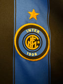Inter badge patch on blue football shirt with black vertical stripes