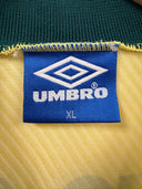 Blue Umbr o size tag on yellow football shirt with diamond logo and “XL”