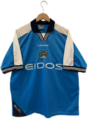 Light blue football shirt with le coq sportif logo, club crest, and EIDOS sponsor
