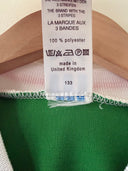 Green soccer home shirt fabric with size/brand label at hem and stitched edging