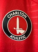 Red football jersey close-up with Charlton Athletic crest and sword emblem
