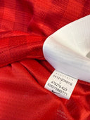 Red football jersey neckline with white size label inside collar seam