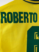 Yellow football shirt front with “ROBERTO” name print in dark green