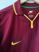 Maroon Portugal home jersey with yellow-trim collar and green Nike swoosh, short sleeve