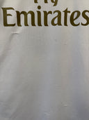 White football jersey with Fly Emirates sponsor text across the front