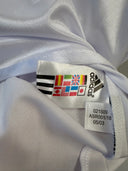 White soccer shirt collar with adidas size tag and multicolor brand label inside seam.