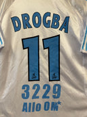 White back of soccer shirt with “DROGBA”, number 11, and “3229 AIIO 0M” below.