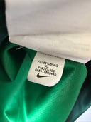 Green football jersey neck with white size/ID label stitched at collar