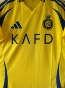 Yellow home soccer shirt with KA F D sponsor text and side blue stripes
