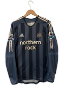 Dark blue striped long-sleeve soccer jersey on hanger with northern rock sponsor