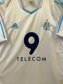 White front of soccer shirt with blue V-neck, adidas mark, crest, number 9, TELECOM.