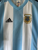 Home soccer jersey front, Adidas logo and AFA crest on light blue-and-white stripes
