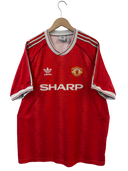Red Manchester United home football shirt on hanger with adidas logo, SHARP sponsor, crest